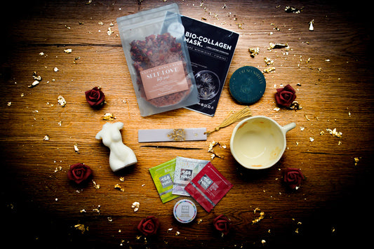 Small Pleasures self-care gift box featuring a wrapped mystery book, ivory Venus torso candle, and floral ceramic teacup.Close-up of the Candle: